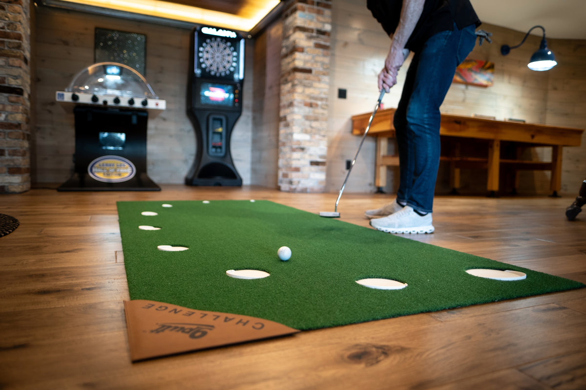 Golfer putting on the 9Putt Mat in a game room