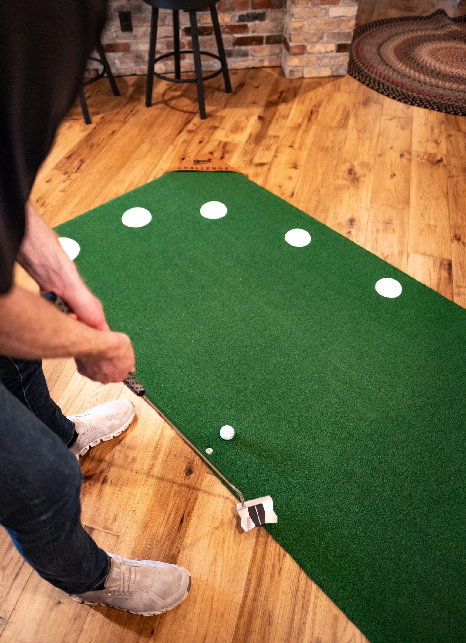 Golfer lining up a putt on the nine-target 9Putt mat indoors