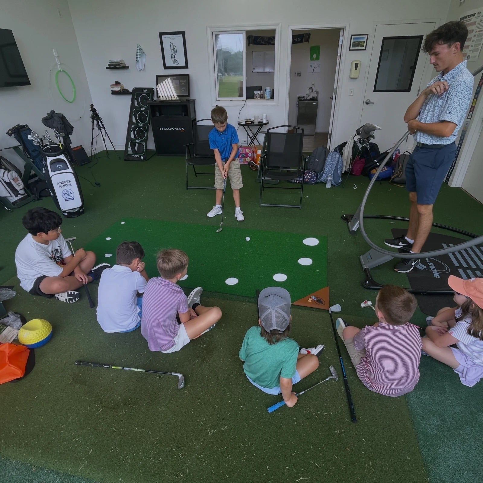 Juniors practicing together on a 9Putt mat during a golf lesson